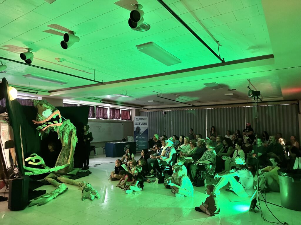 audience watching puppetry show in a green light